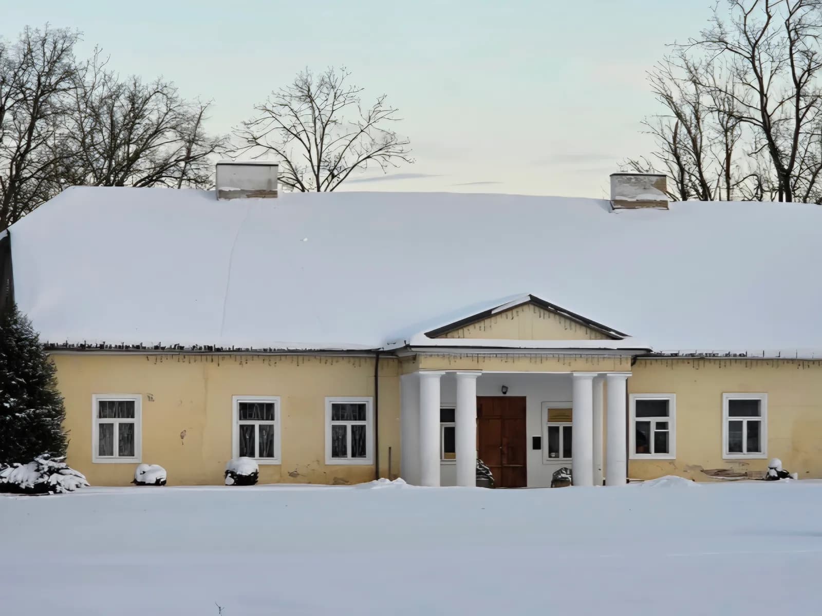 Apsnigtas Šventupės dvaras žiemą, sniegu padengtas stogas ir pieva